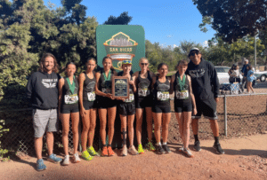 HTH Storm girls cross-country team members pose with their coaches for team photo.
