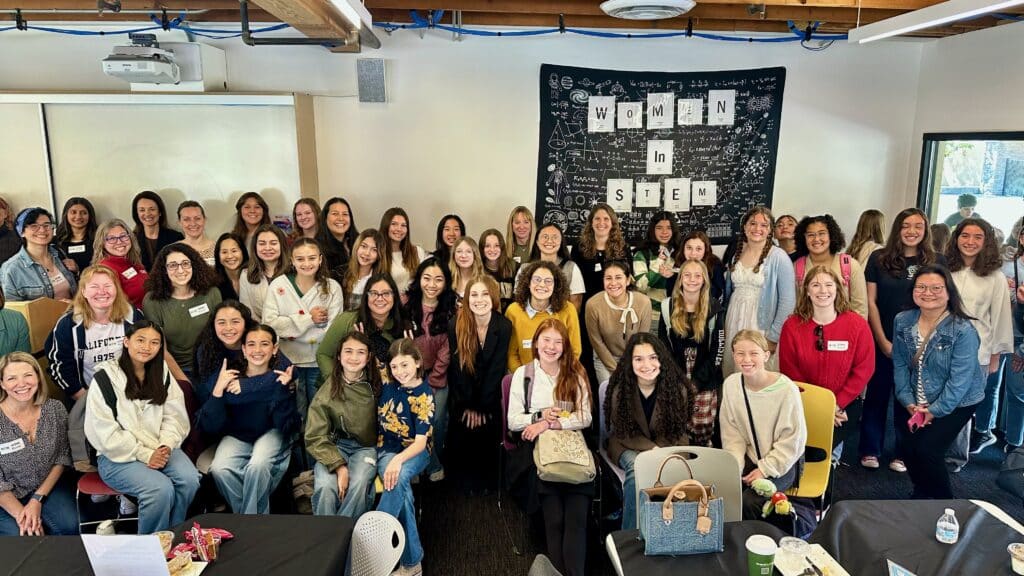 Middle school students and professionals in STEM fields pose for a picture as a group.
