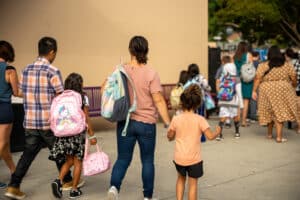Parents walk their children to school.