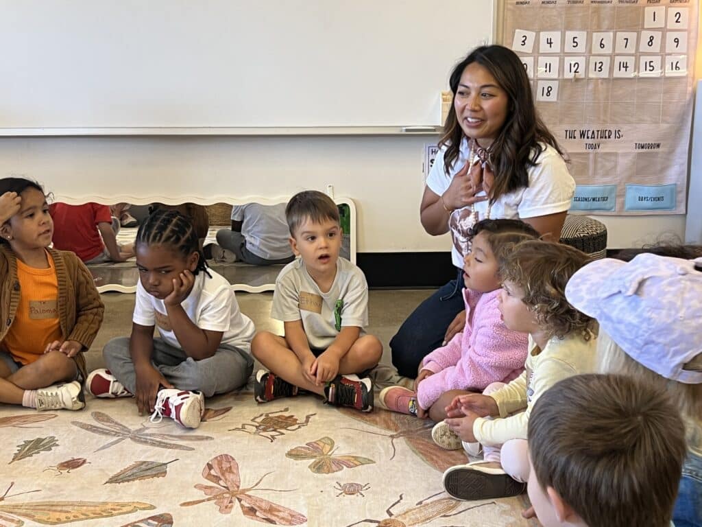 Teacher and students make introductions while seated on the floor at High Tech Elementary Mesa's first Transitional Kindergarten class.