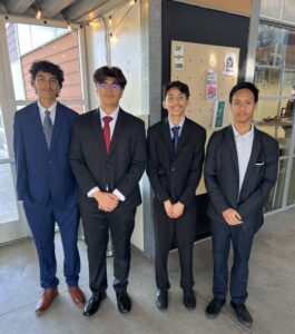 Four students in suits and sport coats await their time for interviews.