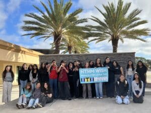 Students at High Tech High Mesa gather together around a banner celebrating Women in STEM.