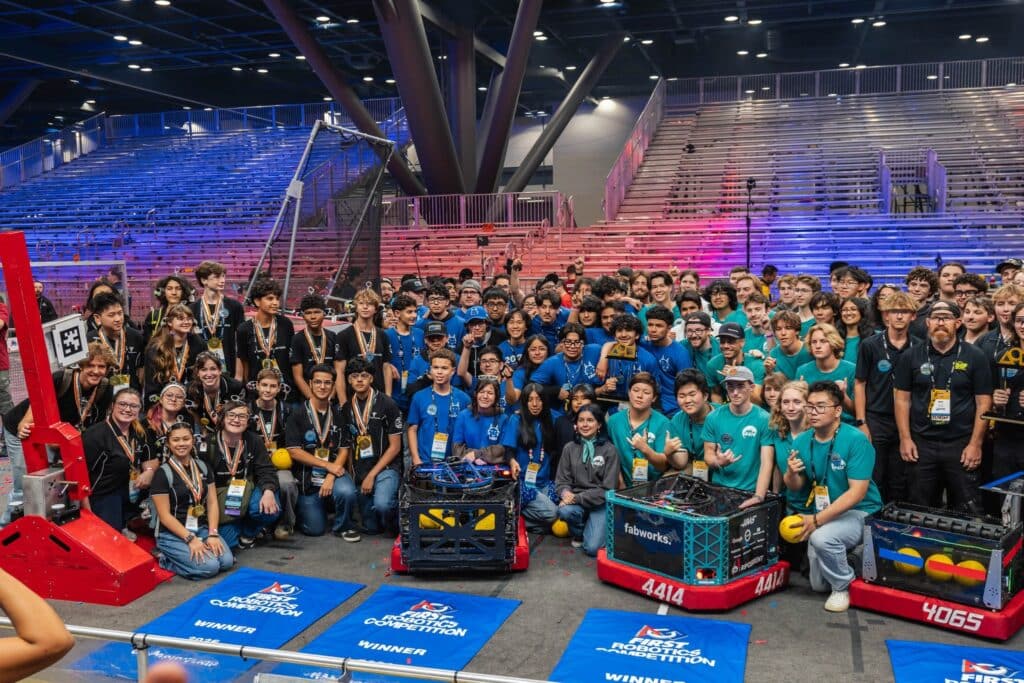 FIRST robotics team members in the winning alliance pose together.